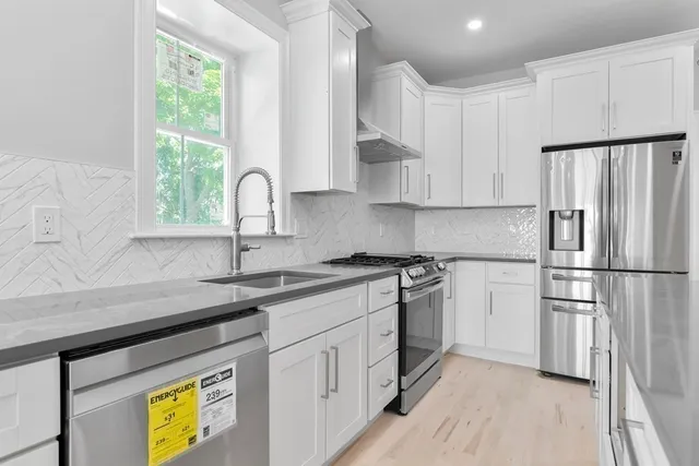 a kitchen with stainless steel appliances granite countertop a refrigerator sink and cabinets