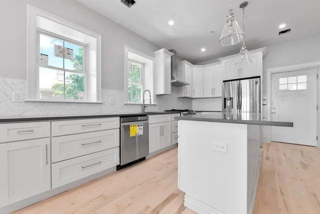 a kitchen with granite countertop cabinets stainless steel appliances a sink and a window