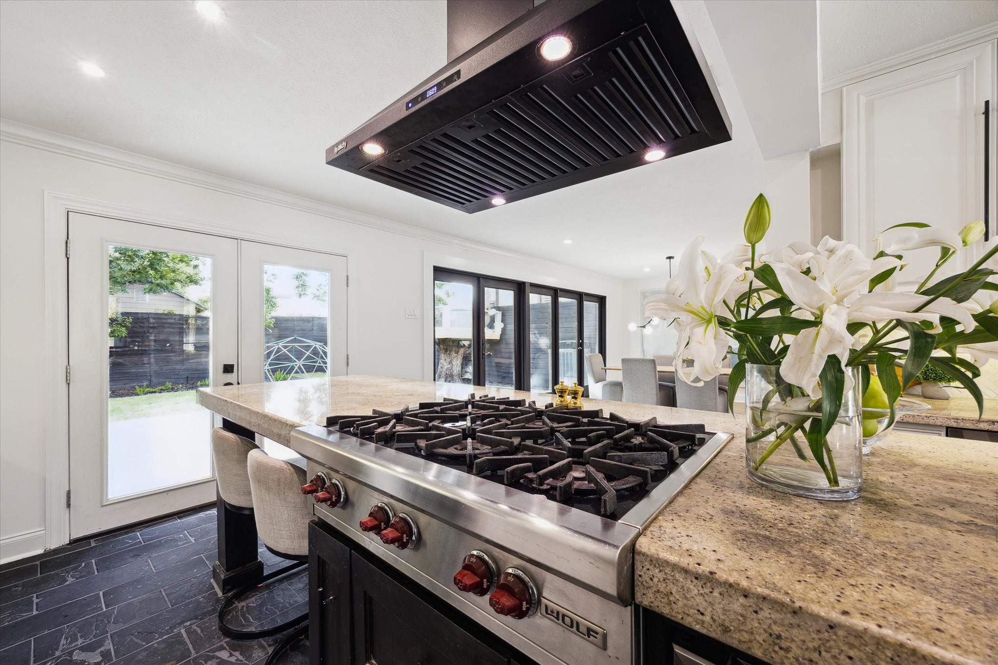4148 Bissonnet Street West University Place, TX 77005 - Photo 16 of 39 a kitchen with granite countertop a stove a chimney a sink and wooden cabinets