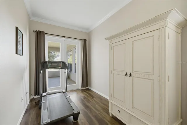 a view of a utility room with closet empty shelves and wooden floor