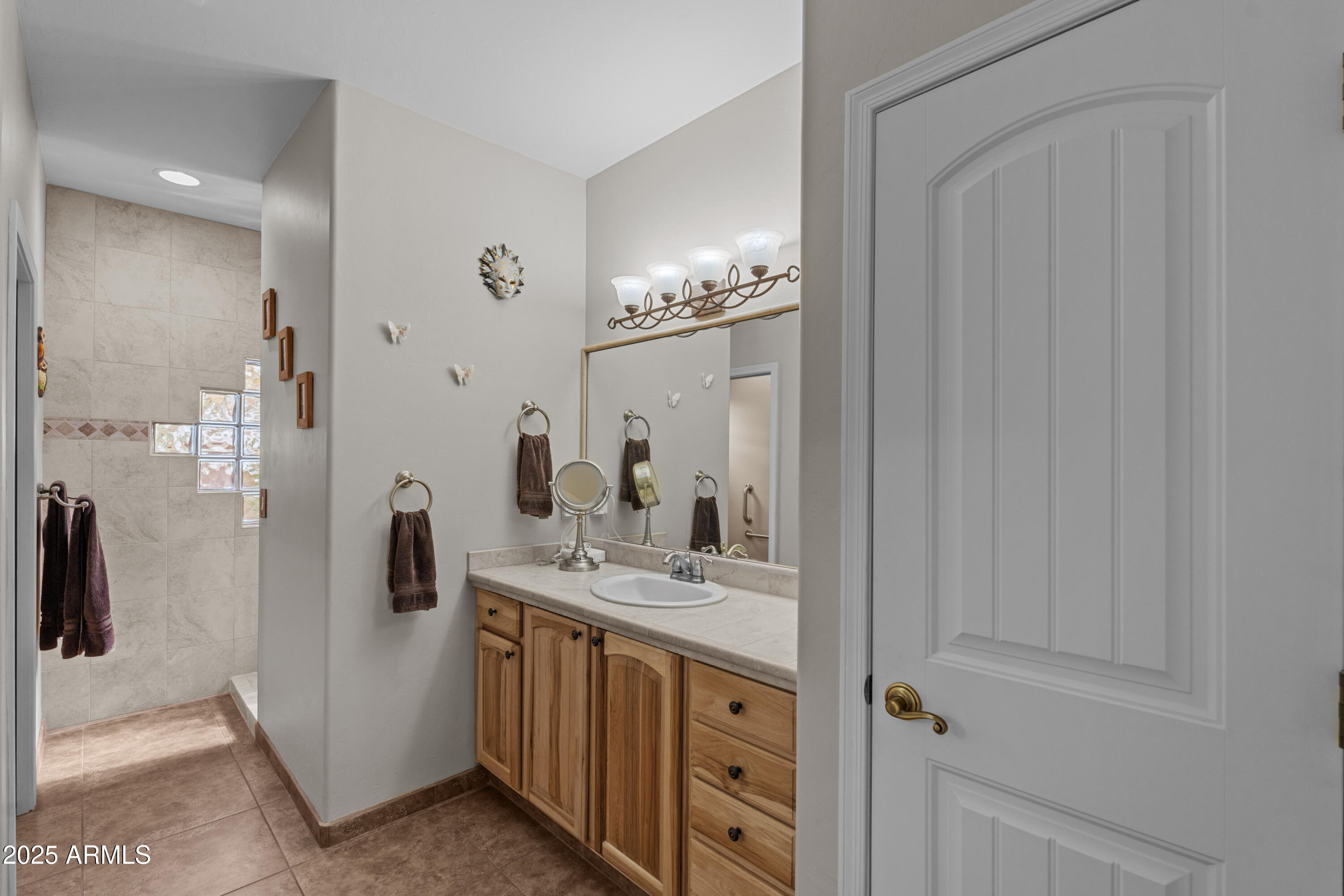 608 Paseo Reforma Rio Rico, AZ 85648 - Photo 22 of 50 a bathroom with a double vanity sink a toilet a mirror and shower
