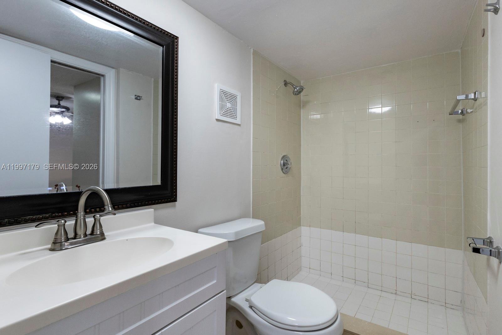 7510 Southwest 152nd Avenue, Unit C104 Miami, FL 33193 - Photo 11 of 14 a bathroom with a sink toilet vanity and shower
