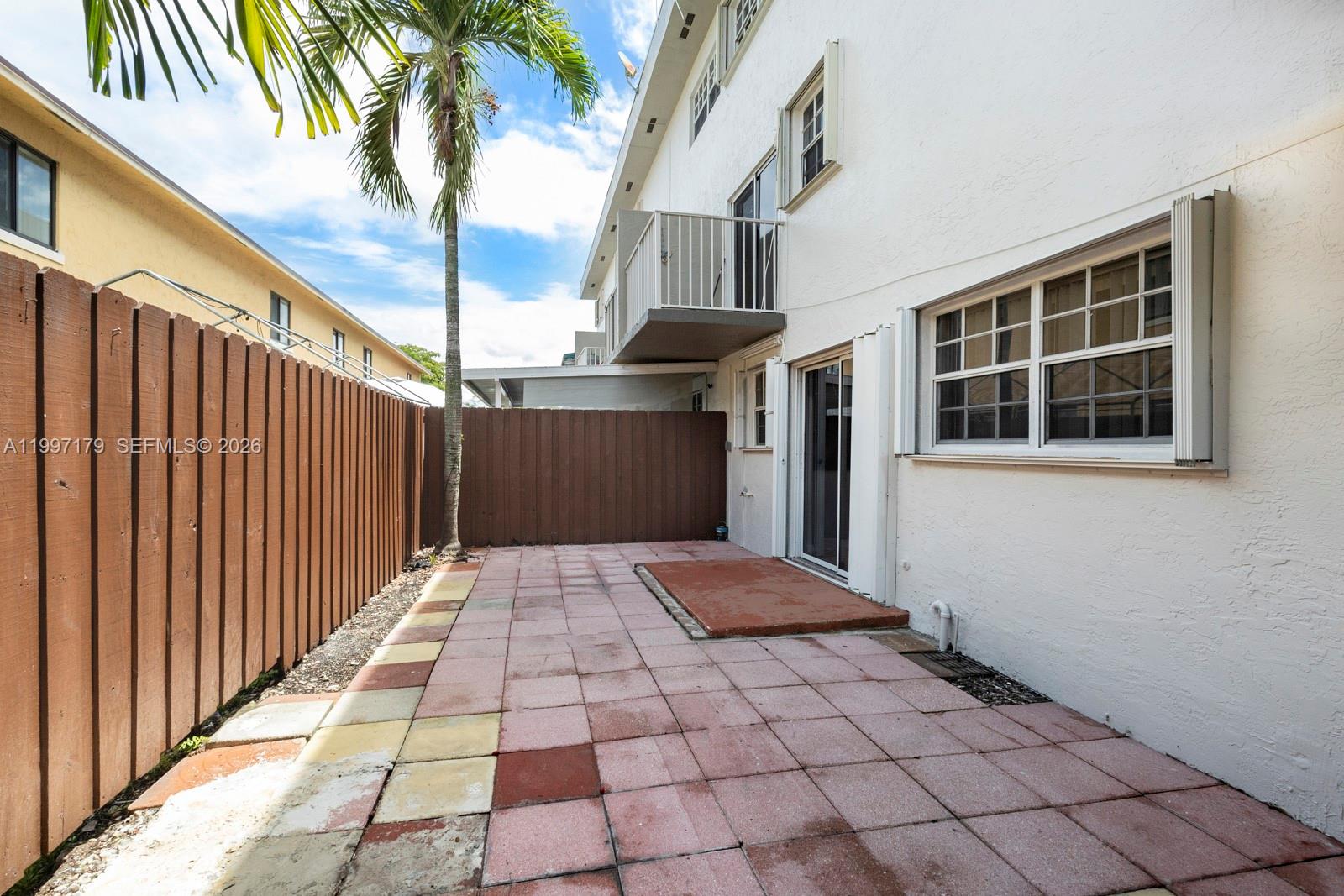 7510 Southwest 152nd Avenue, Unit C104 Miami, FL 33193 - Photo 14 of 14 a view of backyard with large trees and wooden fence