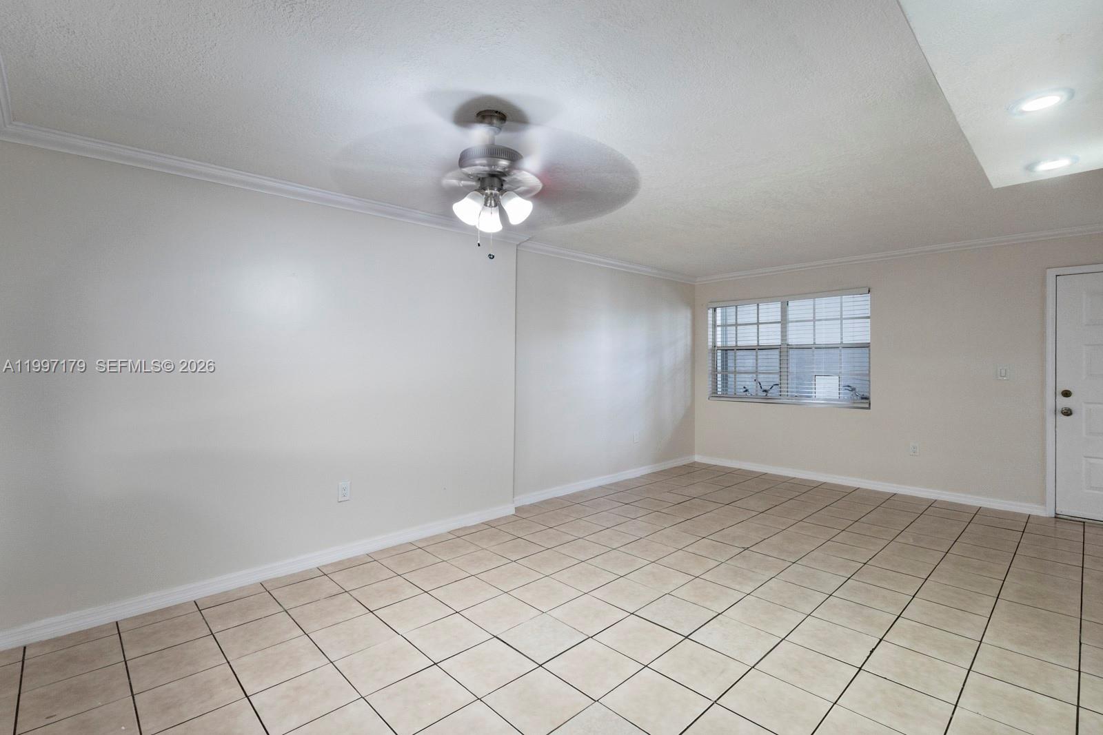 7510 Southwest 152nd Avenue, Unit C104 Miami, FL 33193 - Photo 4 of 14 an empty room with windows and chandelier fan