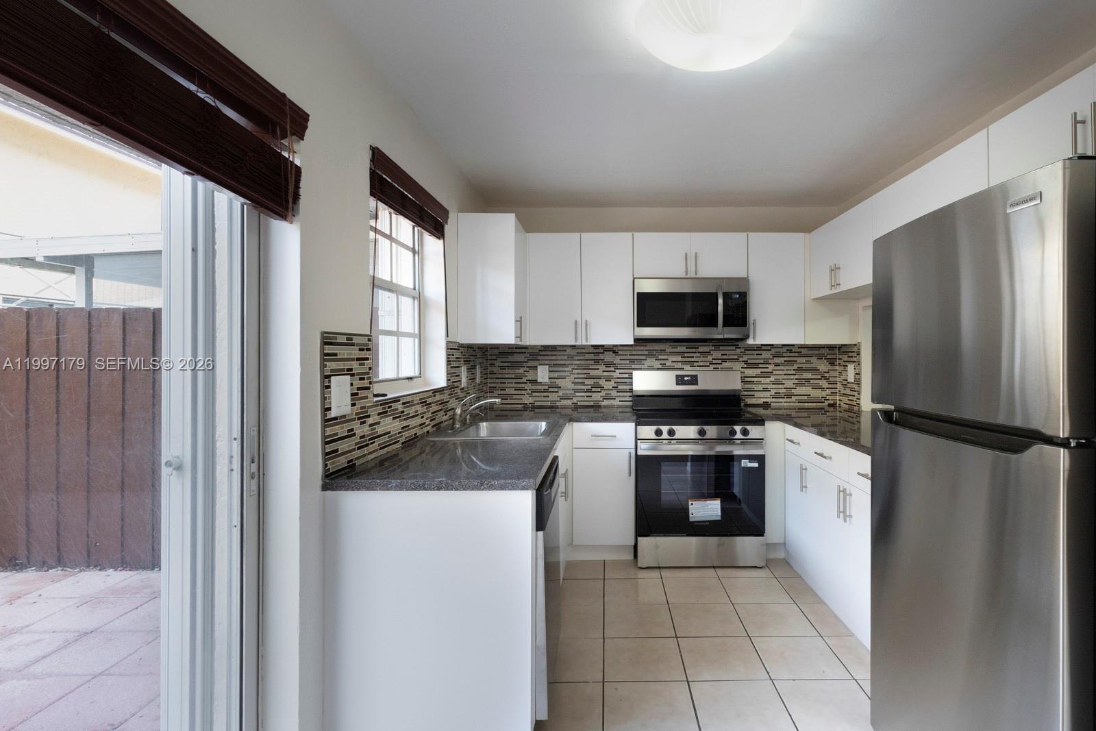 7510 Southwest 152nd Avenue, Unit C104 Miami, FL 33193 - Photo 6 of 14 a kitchen with a refrigerator stove and microwave