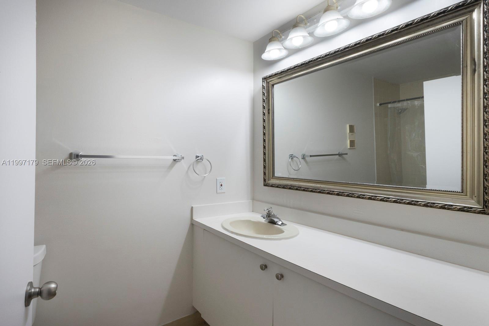 7510 Southwest 152nd Avenue, Unit C104 Miami, FL 33193 - Photo 8 of 14 a bathroom with a sink and a mirror