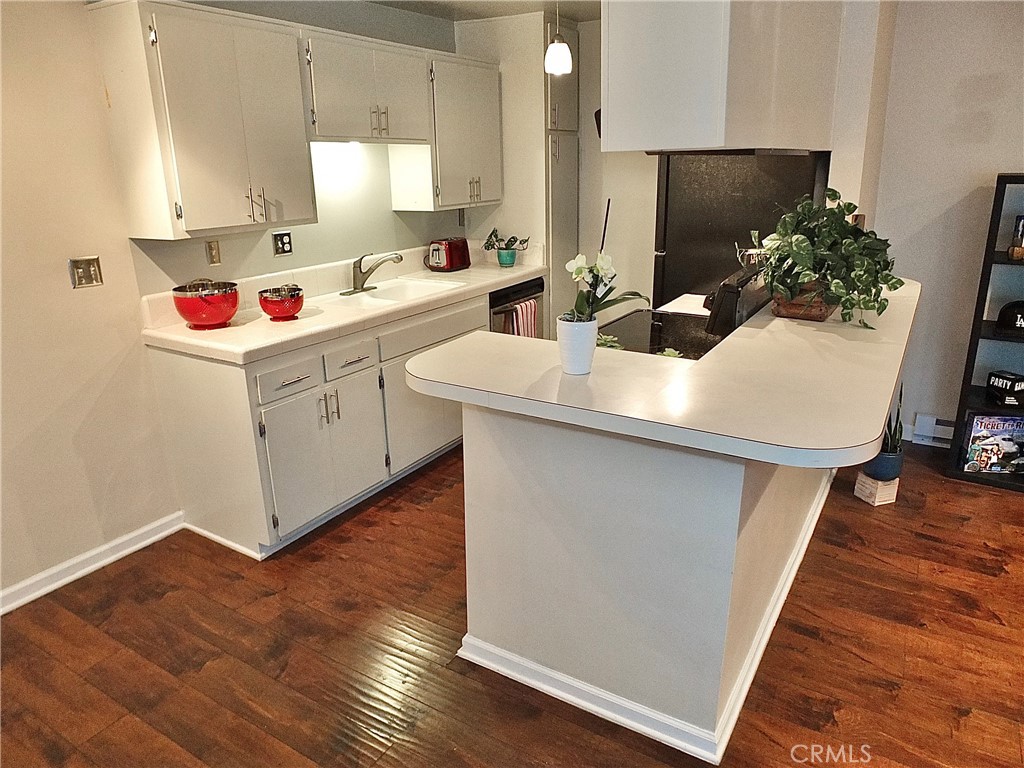 1770 Ximeno Avenue, Unit 314 Long Beach, CA 90815 - Photo 13 of 37 a kitchen with a sink dishwasher stove and microwave with wooden floor