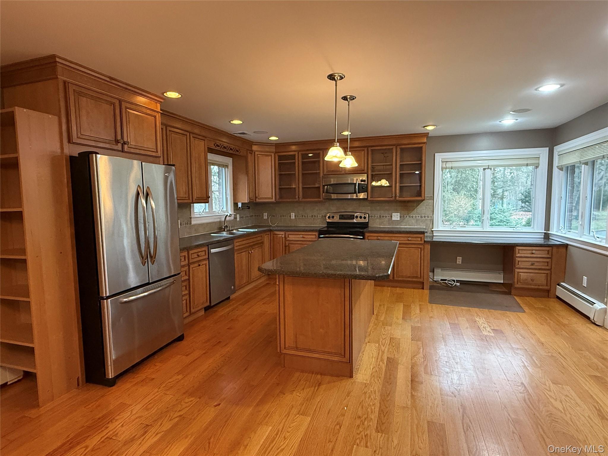 1926 Midlane Road Syosset, NY 11791 - Photo 21 of 21 a kitchen with stainless steel appliances granite countertop a refrigerator a sink dishwasher a stove and a dining table with wooden floor