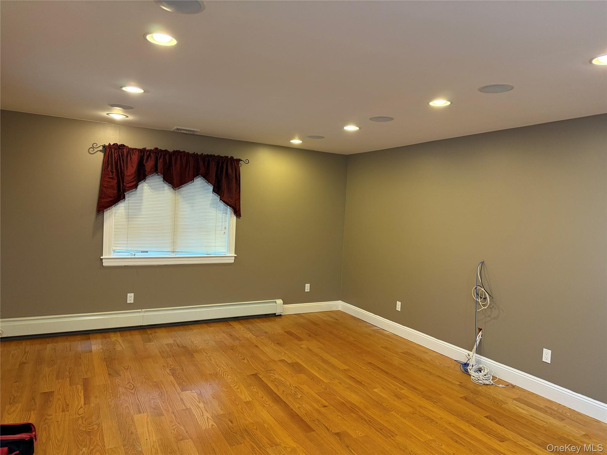1926 Midlane Road Syosset, NY 11791 - Photo 4 of 21 an empty room with wooden floor and windows