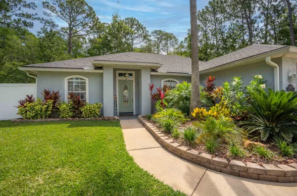 a front view of house with a garden
