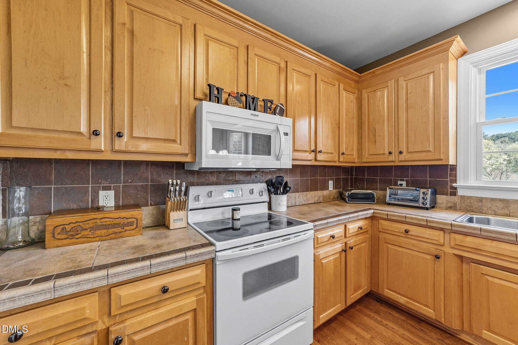 1617 Kendall Hill Road Willow Spring, NC 27592 - Photo 37 of 58 a kitchen with stainless steel appliances granite countertop a sink and cabinets with wooden floor