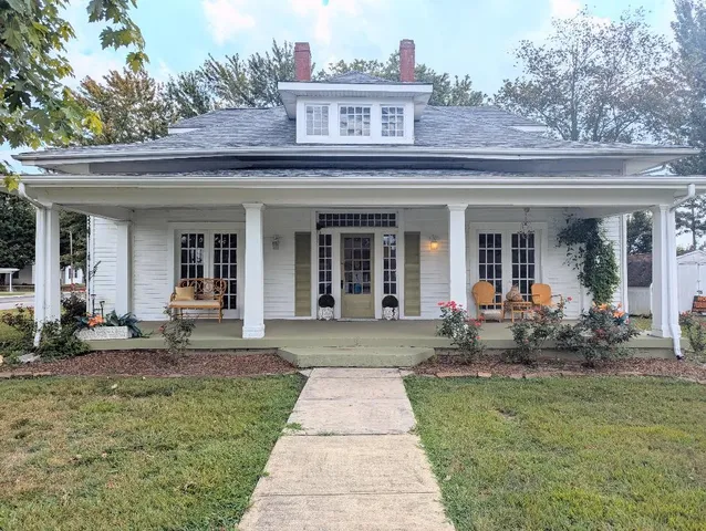 a front view of house with outdoor seating and garden