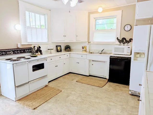 a kitchen with a stove a sink a refrigerator and window