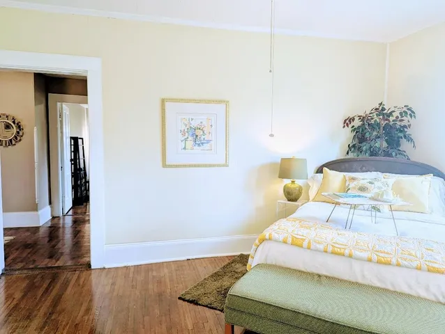 a bedroom with a bed and a painting on the wall