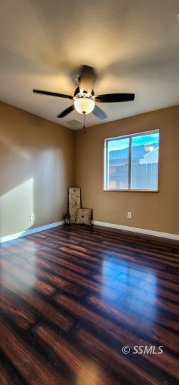 705 Ginger Avenue Ridgecrest, CA 93555 - Photo 15 of 21 a view of room with wooden floor and ceiling fan