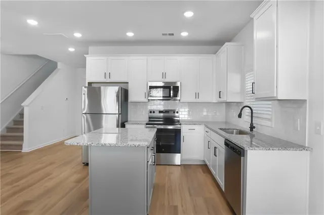 a kitchen with stainless steel appliances granite countertop a sink stove and refrigerator