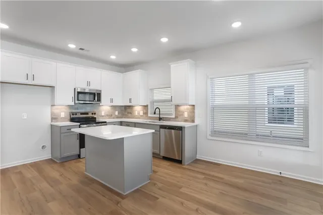 a view of kitchen with microwave a stove and wooden floor