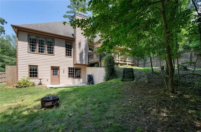 an aerial view of a house with a yard and trees all around