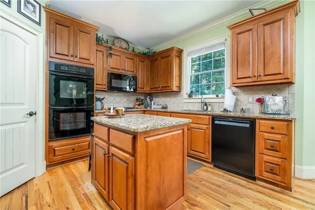 a kitchen with stainless steel appliances granite countertop a stove a sink and a microwave