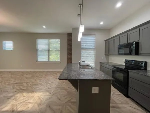 a kitchen with stainless steel appliances granite countertop a sink stove and microwave