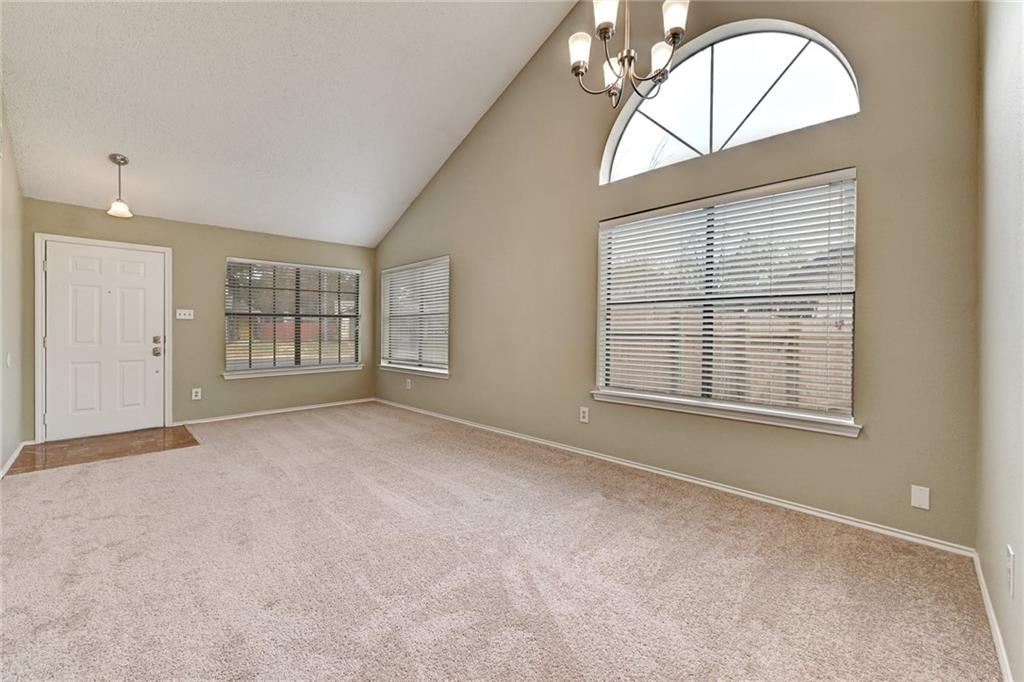 12915 Modena Trail Austin, TX 78729 - Photo 9 of 16 An arched transom window tops the main window in this vaulted living space.