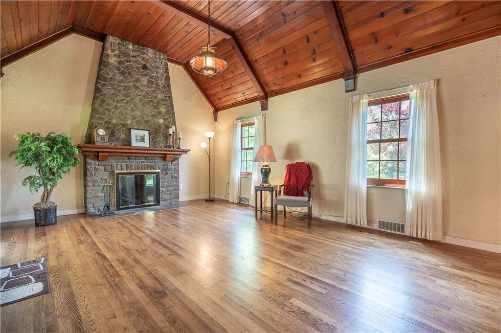 121 Sylvania Drive Pittsburgh, PA 15236 - Photo 5 of 25 LIVING ROOM WITH STONE GAS FIREPLACE, HARDWOOD FLOORS, AND VAULTED WOODED PLANKED CEILING.