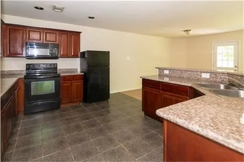 a kitchen with stainless steel appliances granite countertop a refrigerator and a stove