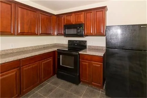 a kitchen with granite countertop stainless steel appliances a stove a microwave and a refrigerator