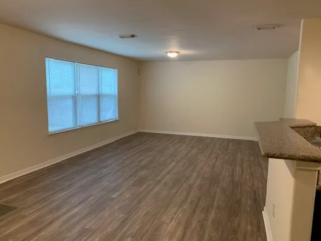 an empty room with wooden floor and cabinet