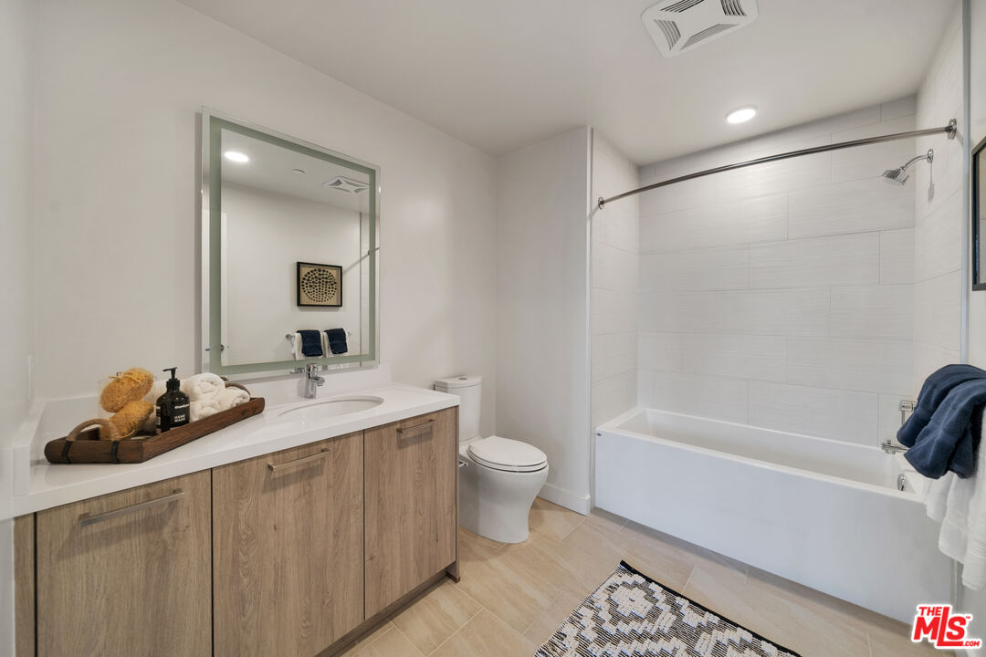 2801 Sunset Place, Unit PH02 Los Angeles, CA 90005 - Photo 11 of 16 a bathroom with a toilet a sink a tub and mirror