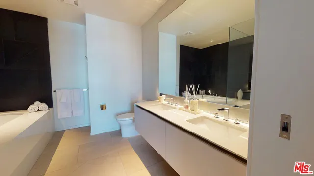 a en suite bathroom with a granite countertop sink and a large mirror