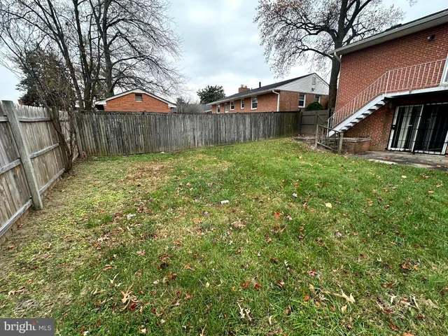 a view of a backyard with table and chairs and wooden fence