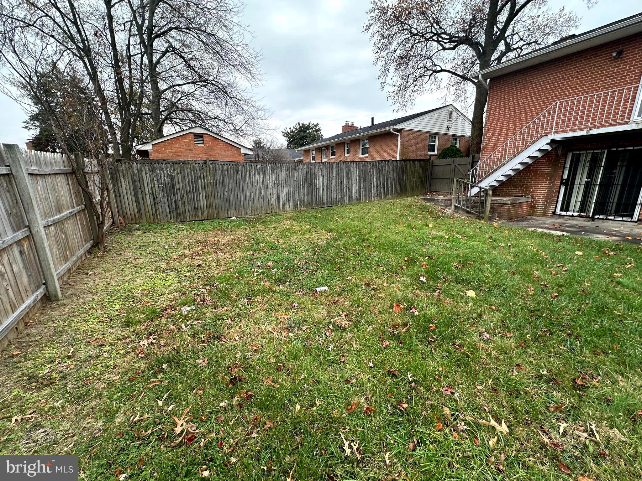 3912 21st Avenue Temple Hills, MD 20748 - Photo 13 of 36 a view of a backyard with table and chairs and wooden fence