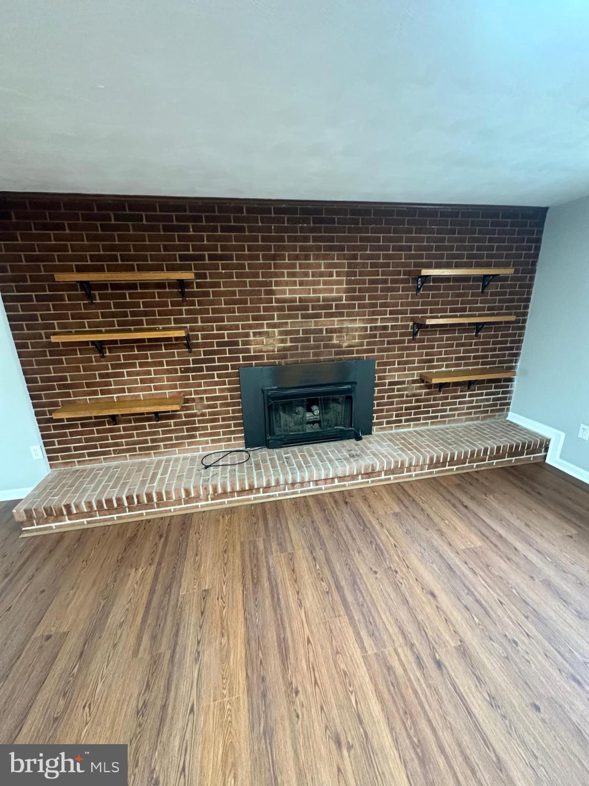 3912 21st Avenue Temple Hills, MD 20748 - Photo 28 of 36 a view of an empty room with wooden floor and a fireplace