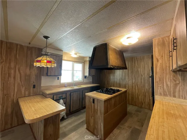 a kitchen that has a lot of cabinets a sink and a stove in it