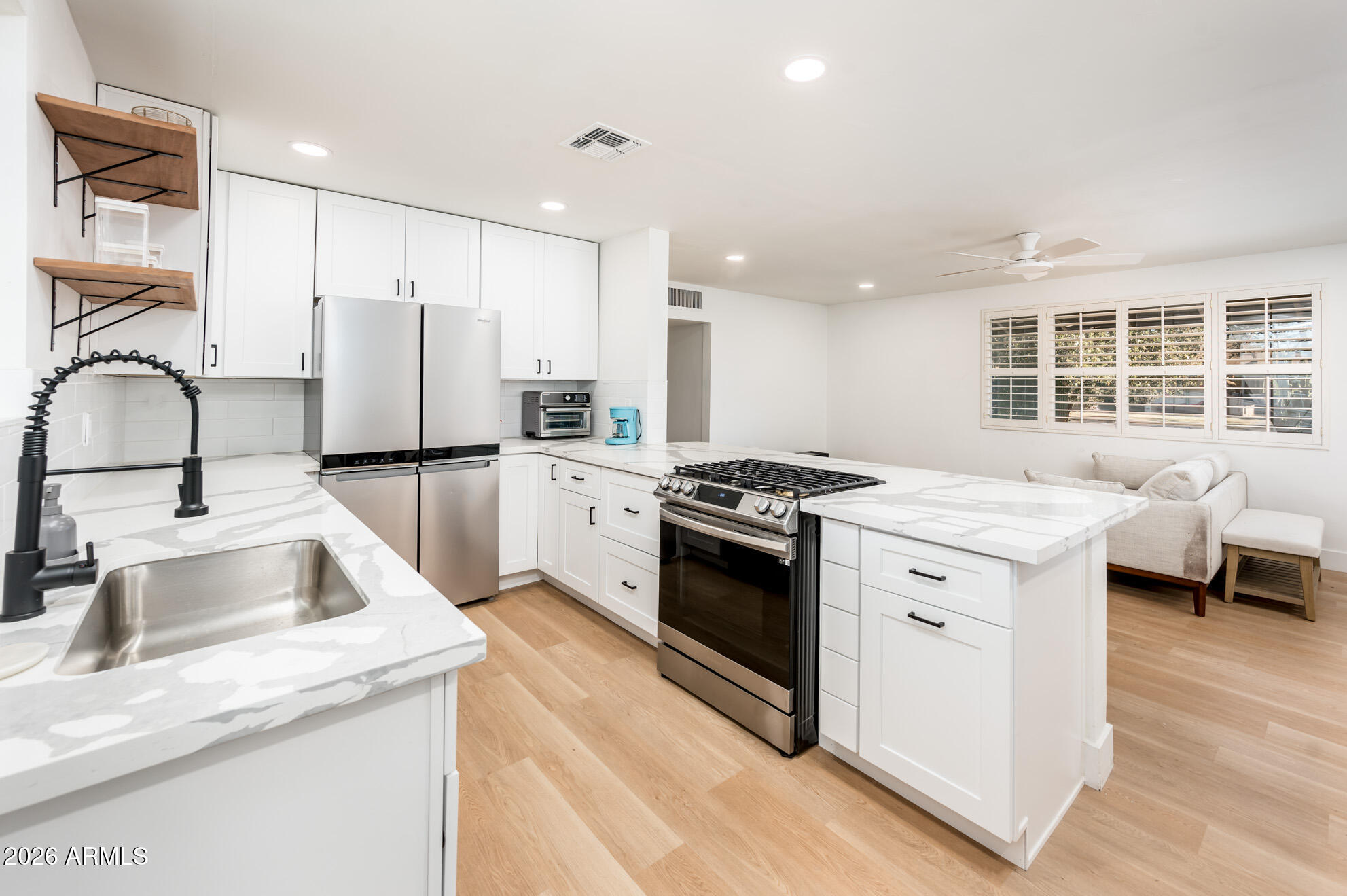 4112 6th Avenue Northwest Phoenix, AZ 85013 - Photo 13 of 23 a kitchen with stainless steel appliances kitchen island granite countertop a sink stove and refrigerator
