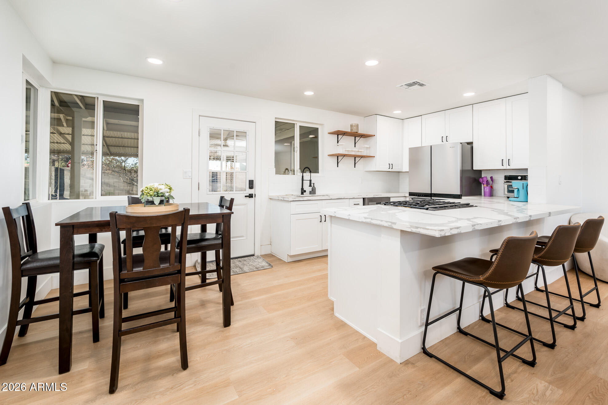 4112 6th Avenue Northwest Phoenix, AZ 85013 - Photo 9 of 23 a kitchen with stainless steel appliances kitchen island granite countertop a dining table chairs and granite counter tops