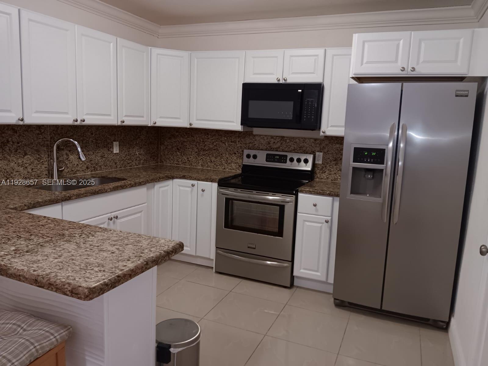 650 Southwest 44th Court Miami, FL 33134 - Photo 12 of 12 a kitchen with granite countertop a sink stove and refrigerator
