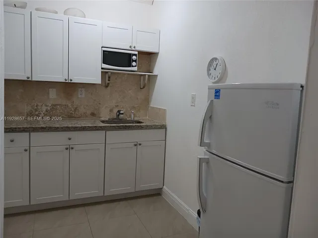a kitchen with stainless steel appliances white cabinets and a refrigerator