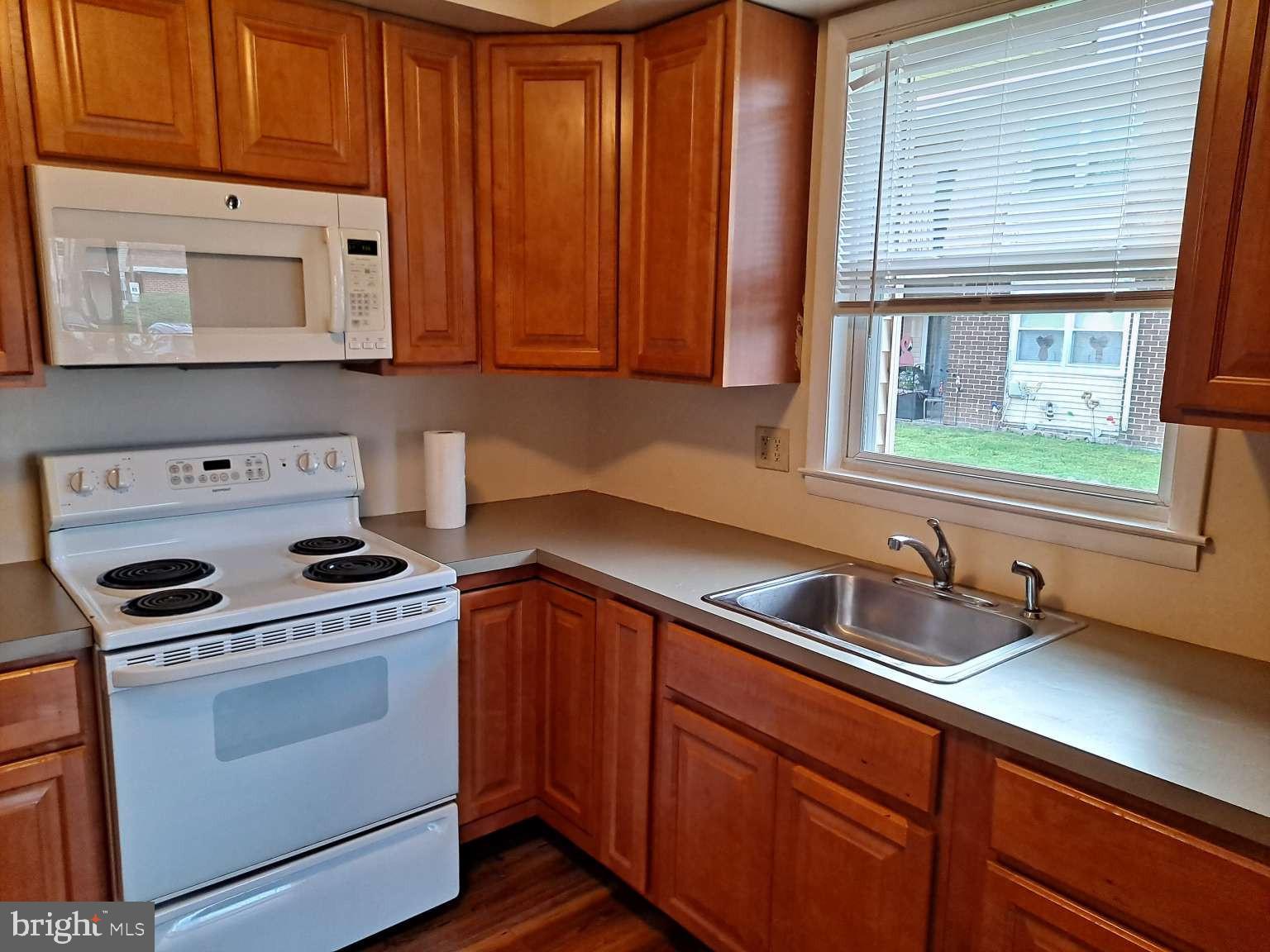 a kitchen with stainless steel appliances granite countertop a sink a stove and cabinets