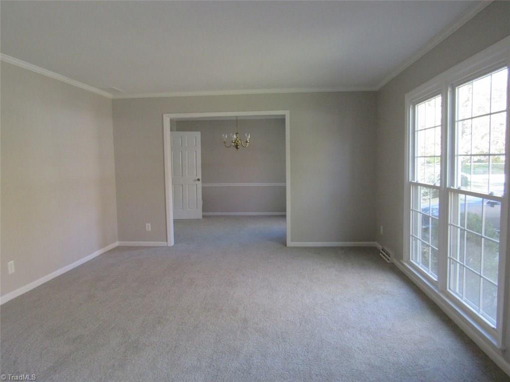 4502 Knightbridge Road Greensboro, NC 27455 - Photo 3 of 15 Formal Living Room with new carpet, freshly painted walls, new replacement windows, crown molding.