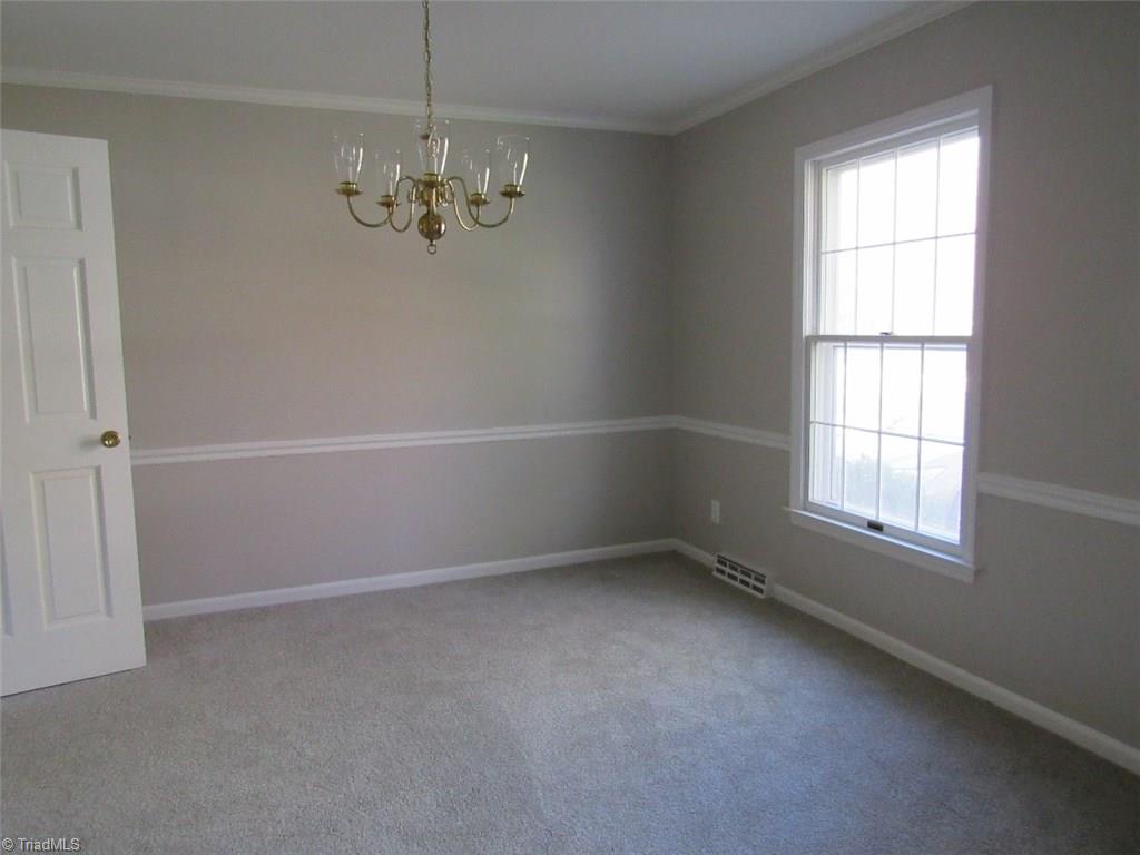 4502 Knightbridge Road Greensboro, NC 27455 - Photo 4 of 15 Dining Room with new carpet, fresh paint crown molding and chair'rail.