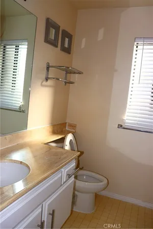 a bathroom with a granite countertop toilet and a sink