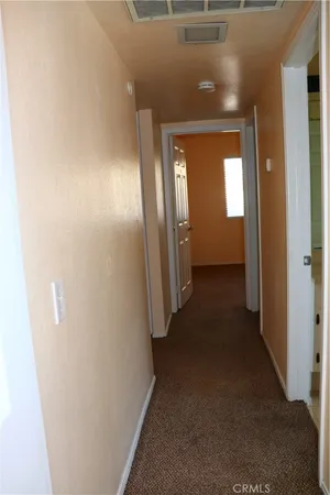 a view of a hallway with wooden shelves