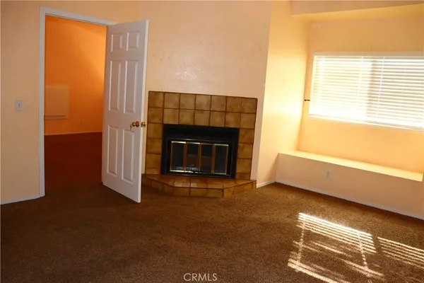 a view of empty room with fireplace and window