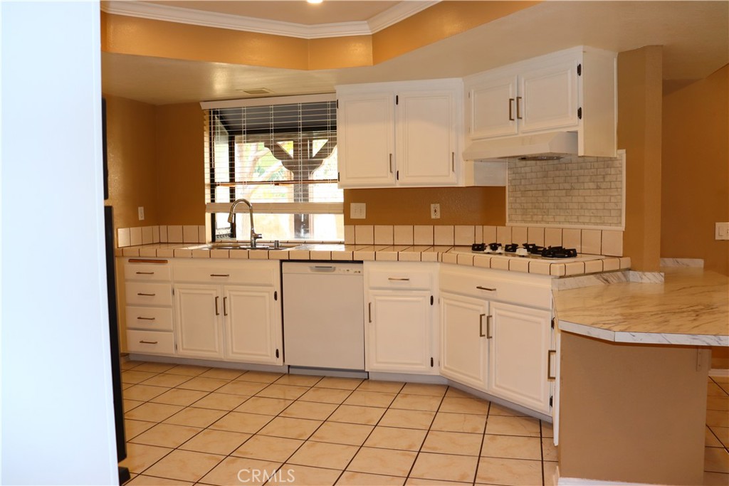 3840 Sago Street Lancaster, CA 93536 - Photo 7 of 23 a kitchen with white cabinets appliances and a sink