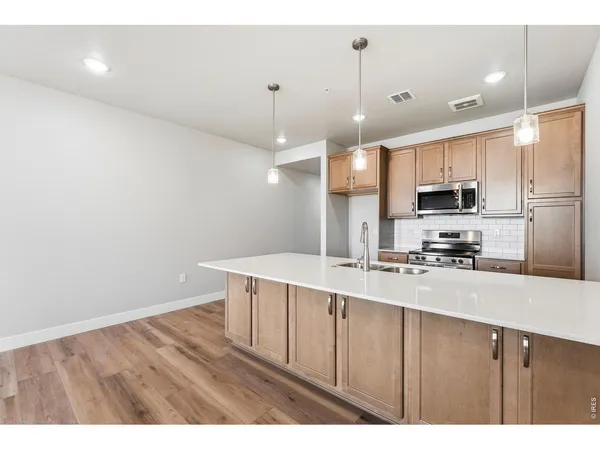 a kitchen with kitchen island a sink stainless steel appliances and cabinets