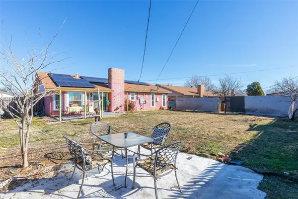 a view of a house with backyard and furniture
