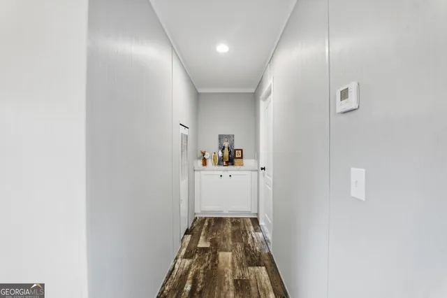 a spacious bedroom with a bed and wooden floor