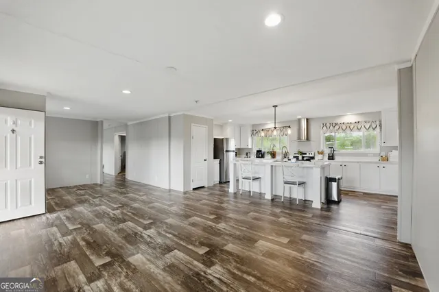 a view of a kitchen with furniture and wooden floor